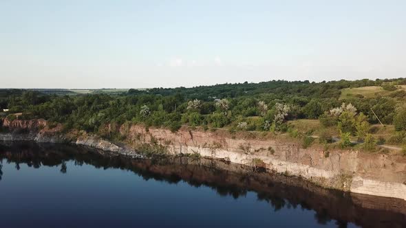 Aerial View. Flying over the quarry lake. Beautiful view of the river landscape.