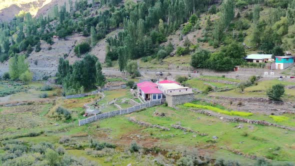 Aerial drone of a local guesthouse hotel located in the mountains of Astore Valley Pakistan on a sun