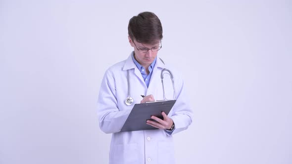 Young Handsome Man Doctor Consulting and Writing on Clipboard