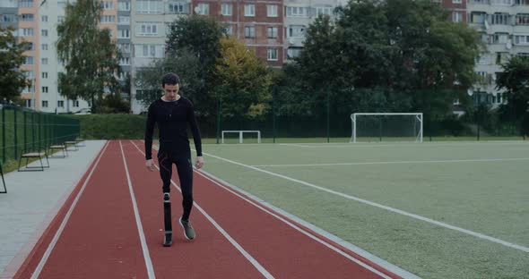 Disabled Strong Spirit Man with Prosthetic Running Blade Walking at Track