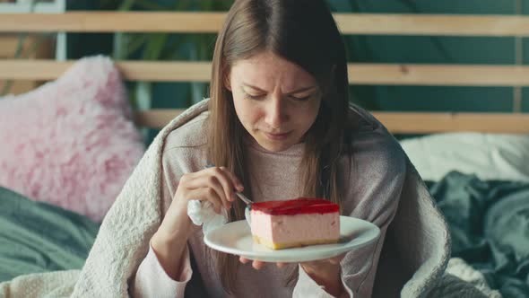 Heartbroken Young Woman Sitting on Sofa Crying Eating Cake Using Tissues