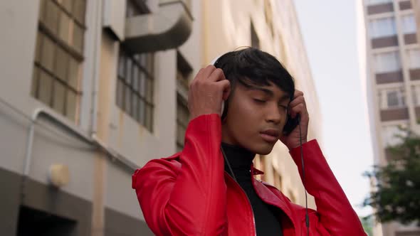 Transgender adult listening to music in the street