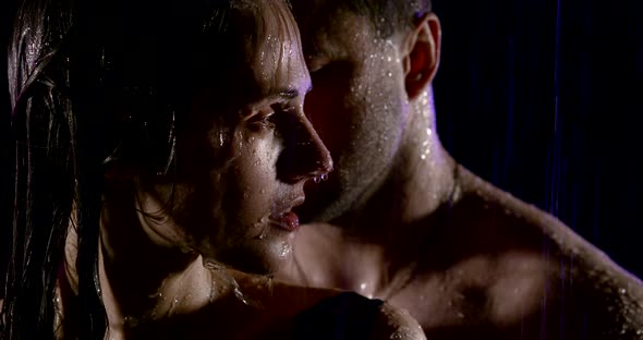 Naked Man and Woman Are in Shower in Darkness, Water Is Falling on Their Skin, Close-up of Faces
