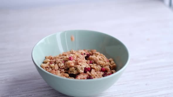 Muesli Pour Into a Ceramic Plate for Cooking Breakfast