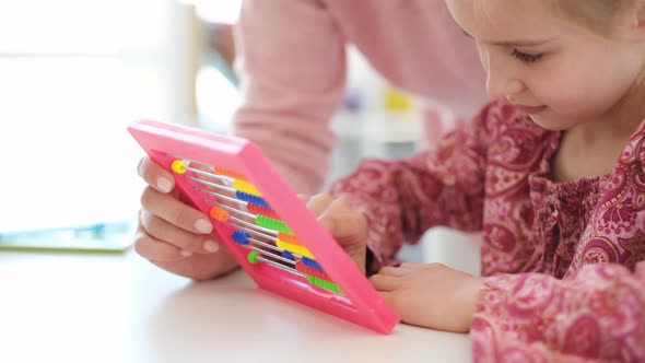 Little Girl Counting on Abacus During Lesson