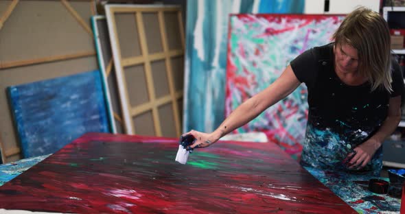 Senior woman painting inside her atelier studio at home