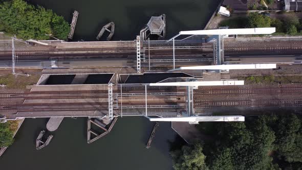 Railway bridge over river Vecht in Holland in the city of Weesp, aerial topdown with passing train