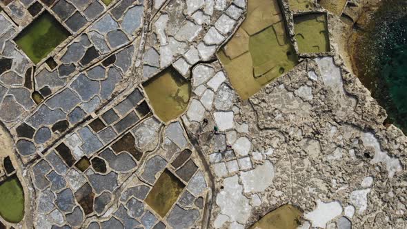 Ascending aerial drone shot of the 300-year-old Salt Pans on the island of Gozo in Malta.