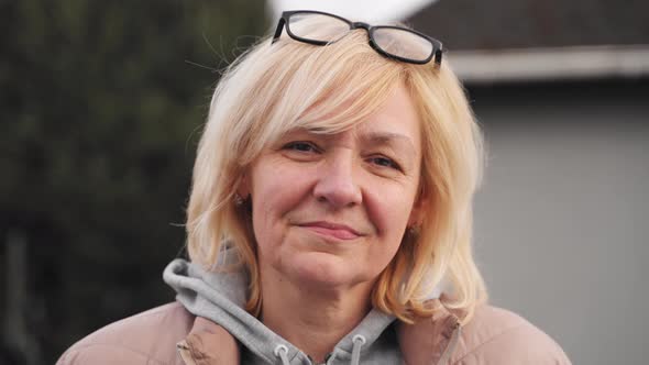 Close Up Video Portrait of Blonde Caucasian Mid Age Woman Outdoors on a Windy Cold Day