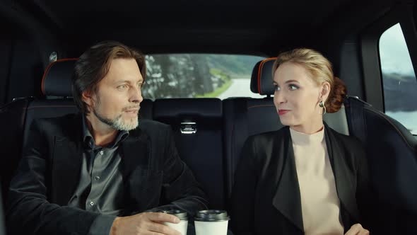 The passengers are a man and a woman, drinking coffee.