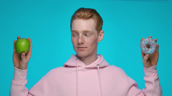 Redhead Man Making Choise Between Apple and Donut