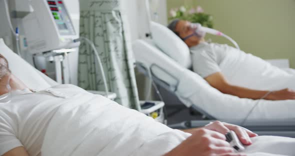 Two male patients lying in hospital beds 