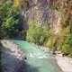 Curvy River Runs in Mountainous Area Between Green Trees - VideoHive Item for Sale