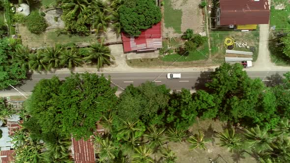 Aerial view following car on road in Batuan, Philippines.