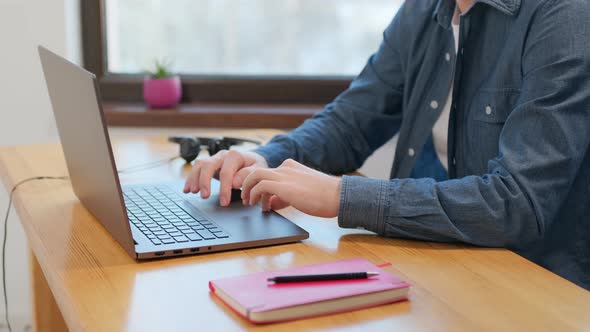 male hands typing working with portable computer laptop at table at home, freelancer is busy