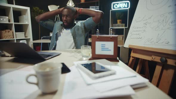 Cheerful African American Businessman Finishing Project at Working Place.