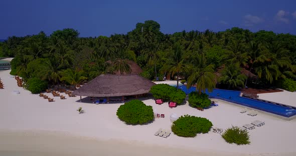 Wide angle drone clean view of a white sand paradise beach and turquoise sea background in vibrant 4