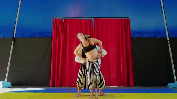 Circus performers practicing partner acrobatics in circus