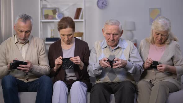 Depressed Senior People Showing Empty Wallets Into Camera, Poverty Problem