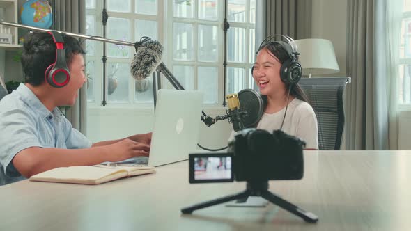 Camera Recording Of Happy Asian Boy Host Record Podcast Interview Kid Girl Guest In Home Studio