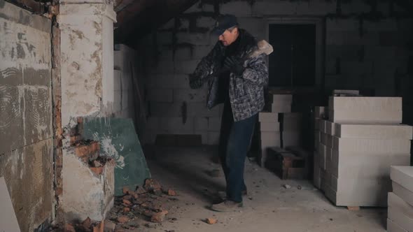 Man Breaks Brick Wall with Sledgehammer