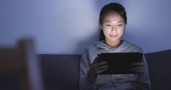 Woman watching on tablet computer at home