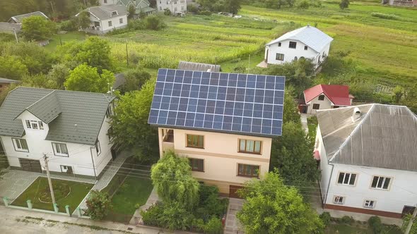 Aerial top view of new modern residential house cottage with blue shiny solar photo voltaic panels 