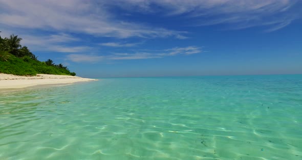 Beautiful drone tourism shot of a white sand paradise beach and blue ocean background in colourful 4