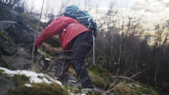 Mature Hiker Clambering Up Hill