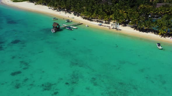 Tropical beach in Mauritius. Sandy beach with palms and blue transparent ocean. Aerial view