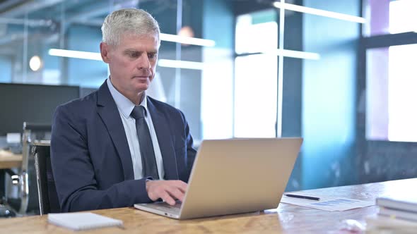 Ambitious Middle Aged Businessman Working on Laptop