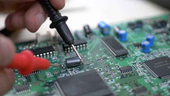 Computer Engineer with Tester Examining Motherboard