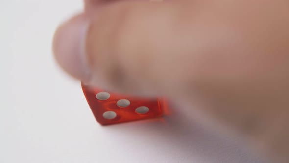 Man Plays with White Spots Dices on Light Background