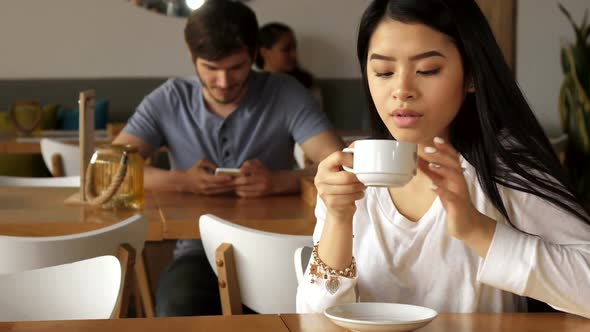 Girl Leans Her Chin on Her Hand at the Cafe