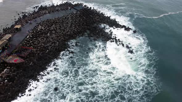 Aerial view of sea wave crashing tetra concrete block or wave breaker stone at Glagah beach, Yogyaka