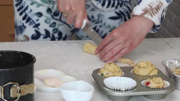 A Woman Cuts A Roll Of Rolled Dough. Prepares Cruffin With Raisins And Candied Fruit.