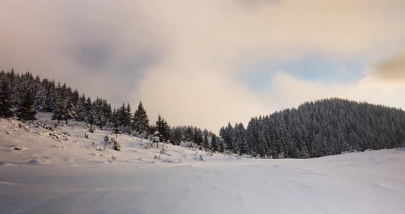 Clouds Rolling Above Snowy Forest Mountains At Sunset - Time Lapse