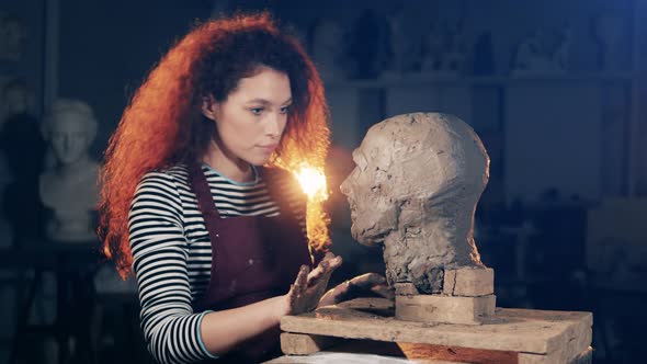 Young Woman is Sculpturing a Clay Head