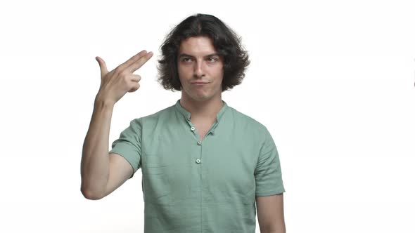 Funny Bored Guy in Green Shirt Making Finger Gun Gesture and Shooting Himself in Head From Boredom
