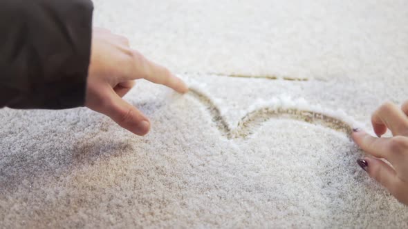 Young Couple Paints Using Their Fingers on the Snow