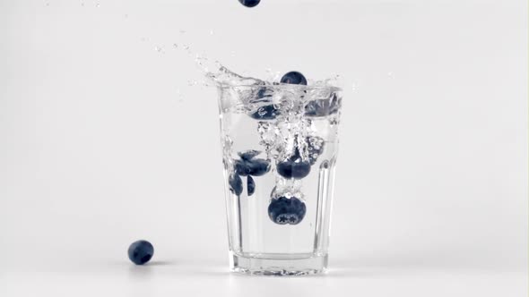 Super Slow Motion of the Blueberries Falls Into a Glass of Water with Splashes