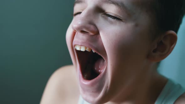 Closeup Face of a Yawning Sleepy Tired Child with a WideOpen Mouth