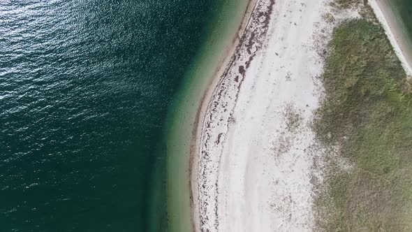 Bird's Eye View Of Glistening Sea With White Sand Beach During Summer In Edgartown, Massachusetts. -