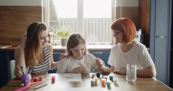 Mother Daughter and Grandmother Paint a Picture Together in the Kitchen