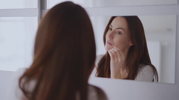 Woman Looking at Mirror at Home