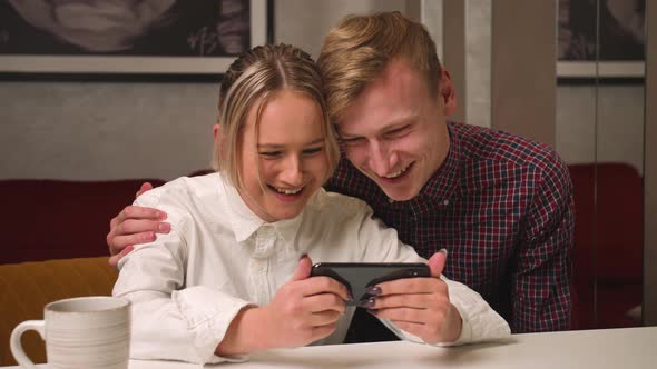 Happy Couple Holds Phone Having Fun Use Online Services Show Photos Watching Content Have Video Call