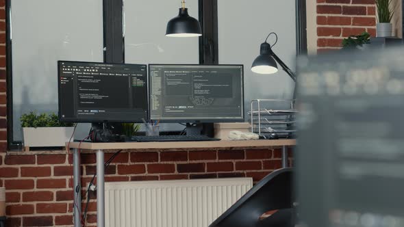 Desk with Multiple Computer Monitors Displaying Parsing Code and Programming Language Compiling