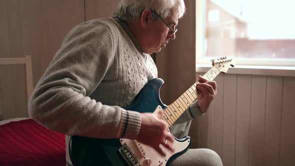 Senior Man is Playing Guitar