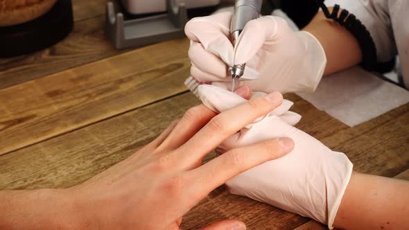 Closeup View of Manicurist Work Who Polishes Clients Nails and Cuticles By Electric Drill