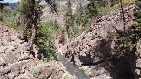 Aerial Fly Up From Base of River to View of Small Mountain Town Ouray Colorado